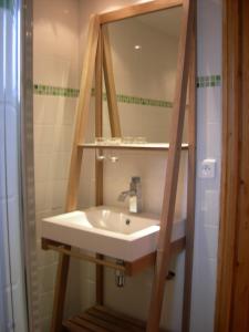 y baño con lavabo y espejo. en Gîte La Penhatière en Baulon