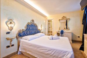 a bedroom with a large white bed with a blue headboard at Hotel Vecellio Venice Lagoon View in Venice