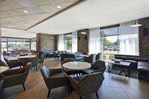 un restaurante con mesas, sillas y ventanas en Hyatt Place Fresno, en Fresno