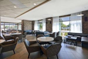un restaurant avec des tables, des chaises et des fenêtres dans l'établissement Hyatt Place Fresno, à Fresno