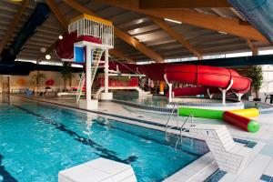 a pool with a slide and a water slide at Hebrechthuis in Vlagtwedde