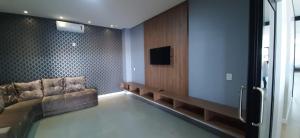a living room with a couch and a tv at Hotel Alvorada - Trindade do Sul in Trindade