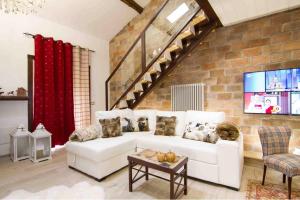 salon z białą kanapą i ceglaną ścianą w obiekcie Loft Giuly w mieście Vignanello