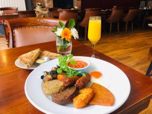 a table with a plate of food and a glass of orange juice at Friars Wynd Hotel in Stirling