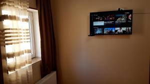 einen Flachbild-TV an einer Wand neben einem Fenster in der Unterkunft Guest house Jangulashvili in Sighnaghi