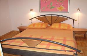 スヴェタ・ネデリャにあるApartments Dijana - economy apartmentsのベッド1台(木製ヘッドボード、オレンジ枕2つ付)