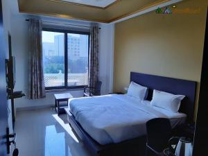 1 dormitorio con cama y ventana grande en Jeenmount Heritage Boutique Hotel, en Jaipur