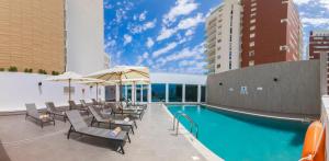 a pool with chairs and umbrellas on a building at Holiday Inn Algiers - Cheraga Tower, an IHG Hotel in Alger