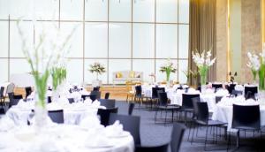 a room filled with tables and chairs with white table settings at Holiday Inn Algiers - Cheraga Tower, an IHG Hotel in Alger