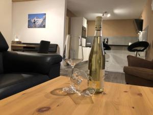 butelkę wina i kieliszek na stole w obiekcie Haus Bergsicht Lofer w mieście Lofer