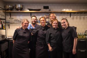 a group of chefs posing for a picture in a kitchen at Hotell Bondeheimen in Oslo