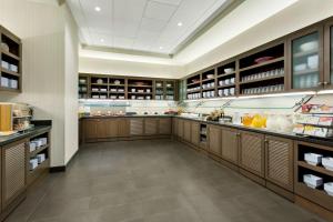 a large kitchen with wooden cabinets and a lot of food at Hyatt Place Chicago/Downtown - The Loop in Chicago