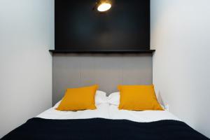un letto con due cuscini gialli sopra di Warsaw Prince Studio by Renters a Varsavia