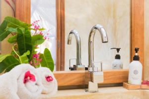 un lavandino in bagno con asciugamano e specchio di UVIVU by Jambiani Villas a Jambiani