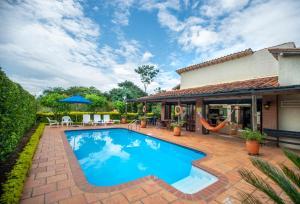 a swimming pool with a patio and a house at Fincas Panaca JAGÜEY 21 Grupo VIP in Quimbaya