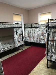 2 łóżka piętrowe w pokoju z czerwonym dywanem w obiekcie Хостел Тихий дворик w Charkowie