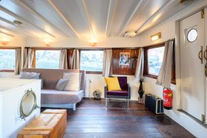 a train room with a bed and a couch at Boatapartment Animathor on top location in Rotterdam