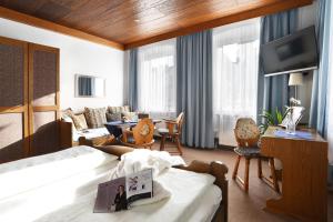 ein Hotelzimmer mit einem Bett und einem Wohnzimmer in der Unterkunft Gasthof & Hotel Goldener Hirsch in Bad Berneck im Fichtelgebirge