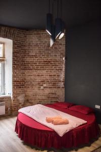リヴィウにあるКвартира з круглим ліжком, вулиця Гоголя 9, в стилі Лофт цікавий стиль і комфортのレンガの壁のドミトリールームのベッド1台分です。