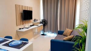 a living room with a couch and a tv at Porto de Galinhas - Muro Alto Condomínio Clube in Ipojuca