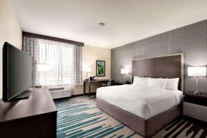 a hotel room with a bed and a flat screen tv at La Quinta by Wyndham Clovis CA in Clovis