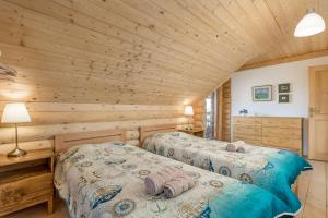 a bedroom with two beds in a log cabin at Mountain family home Nola Ivano in Delnice
