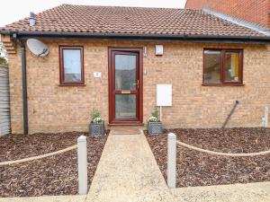 a brick house with a fence in front of it at Village Retreat in Ely