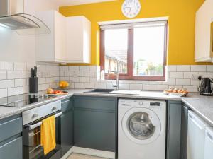 a kitchen with a washing machine and a window at Village Retreat in Ely +7 photos