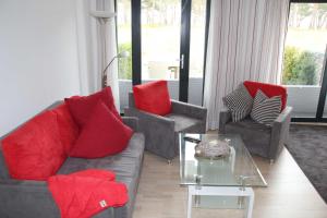 ein Wohnzimmer mit Sofas und roten Kissen in der Unterkunft Strandresidenz Appartement Kormoran A07 in Binz