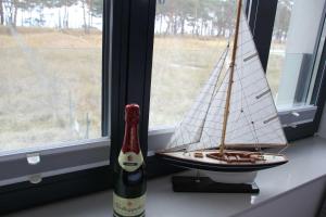 eine Flasche Wein und ein Miniaturboot auf einem Fensterbrett in der Unterkunft Strandresidenz Appartement Kormoran A07 in Binz