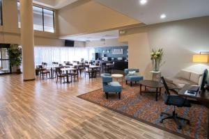 a lobby with a waiting room with tables and chairs at Sleep Inn & Suites Pearland - Houston South in Pearland