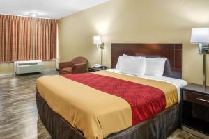 a hotel room with a large bed and a chair at Econo Lodge near Missouri University of Science and Technology in Rolla
