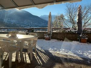 a table and chairs on a patio in the snow at Trento Small View in Trento