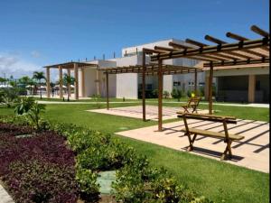 a park with a picnic bench and a building at Porto de Galinhas - Muro Alto Condomínio Clube in Ipojuca