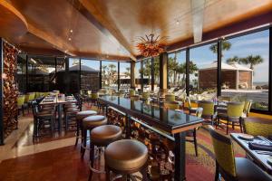 a restaurant with a bar with chairs and tables at Holiday Inn Resort Galveston - On The Beach by IHG in Galveston