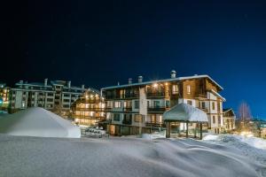 a large building in the snow at night at Green Life Bansko in Bansko