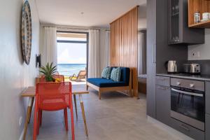 a kitchen with a table and a dining room with the ocean at La Desirade in Mahe