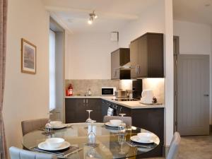 a kitchen with a table and chairs in a kitchen at Grosvenor House APT 1 in Aberystwyth