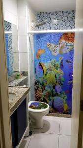 a bathroom with a fish shower with a toilet at Porto de Galinhas - Muro Alto Condomínio Clube in Ipojuca