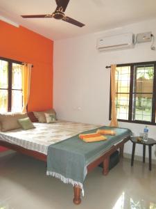 a bedroom with a bed with an orange wall at Kochill - Relax & Stay - in Cochin