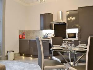 a kitchen with a table and chairs in a kitchen at Grosvenor House APT 3 in Aberystwyth