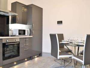 a kitchen with a table and chairs and a microwave at Grosvenor House APT 3 in Aberystwyth