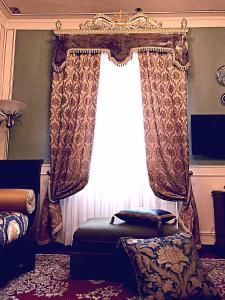 a bedroom with a window with curtains and a chair at VILLA MARRONE - Relais - in Marsala