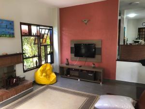 ein Wohnzimmer mit einem Flachbildfernseher an der Wand in der Unterkunft Casa de Praia Riviera de Sao Lourenco - Vilagio in Bertioga