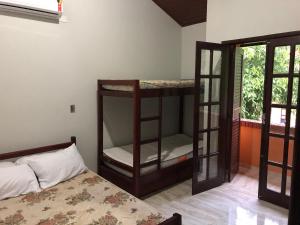ein Zimmer mit zwei Etagenbetten und einem Bett in der Unterkunft Casa de Praia Riviera de Sao Lourenco - Vilagio in Bertioga + 50 Fotos