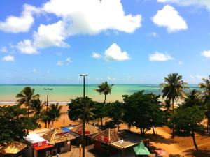 a view of a beach with palm trees and the ocean at VOA Ambassador Flat in João Pessoa