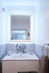 a bathroom with a sink and a mirror at The Duplex with Air Conditioning & Private Deck Area in Margate