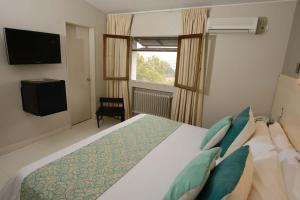 Un dormitorio con una cama grande y una ventana en Portezuelo Hotel en Salta