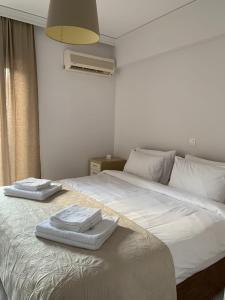 een wit bed met twee handdoeken erop bij Treasure cosy flat in Athene