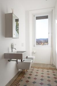 baño blanco con lavabo y ventana en Villa Jejia, en Lesa